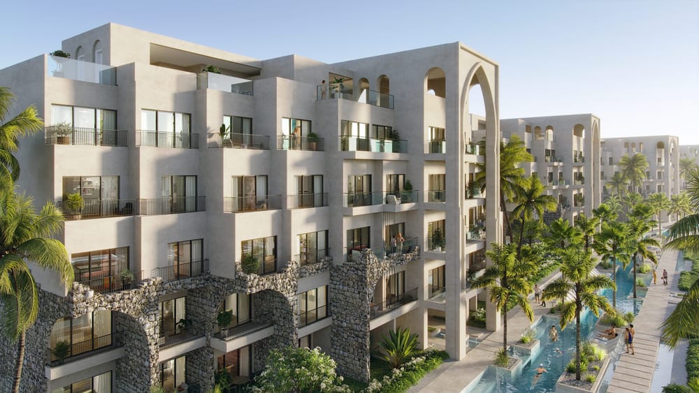Fachada de Poseidonia Residences con arquitectura de inspiración europea y jardines tropicales en Cana Bay, Punta Cana