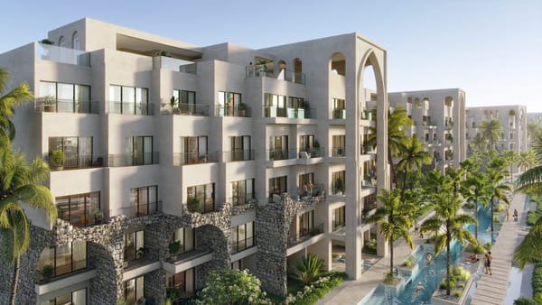 Fachada de Poseidonia Residences con arquitectura de inspiración europea y jardines tropicales en Cana Bay, Punta Cana